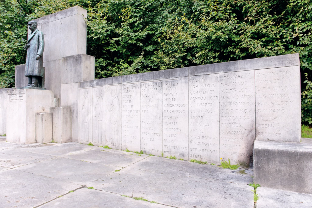 Een monument dat bestaat uit een bronzen beeld van de wetenschapper Hendrik Antoon Lorentz op een hoge sokkel, daarachter een muur gemaakt van grote stenen blokken van ongeveer twee meter hoog. Op de blokken staan namen gekerfd van wetenschappers die Lorentz heeft geïnspireerd.